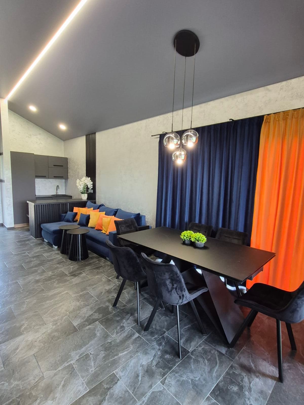 Erdvi svečių namelio svetainė su mėlyna sofa